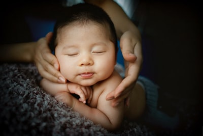 婴儿躺在灰色的纺织品
